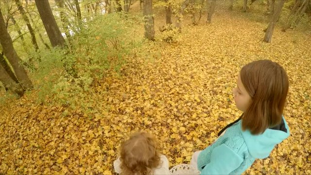 Children walk along the yellow foliage