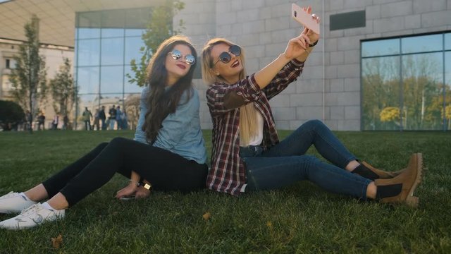 Happy gilrls selfie in park. Two hipster girlfriends taking photos in park. Girls selfie outdoor.