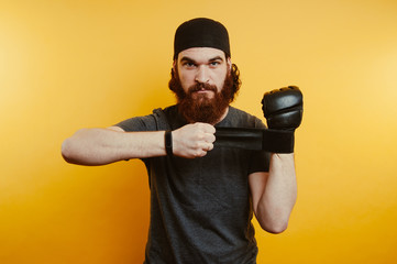 Bearded Man preparing gloves for fighting