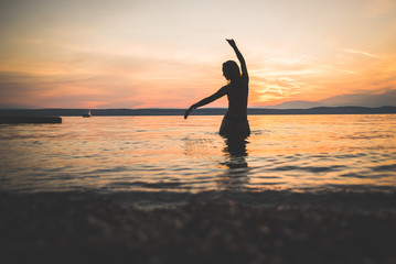 Young attractive girl model silhouette in the water