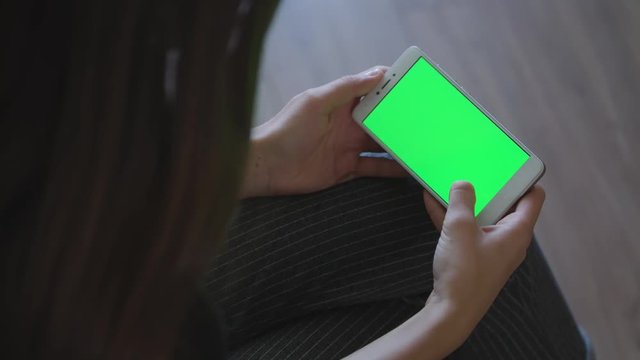 Excited girl playing video games on smartphone.Green screen hromakey