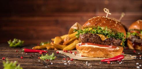 Delicious hamburger with fries, served on wood