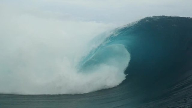 Man body surfing a perfect barrel in teahupoo french polynesia tahiti