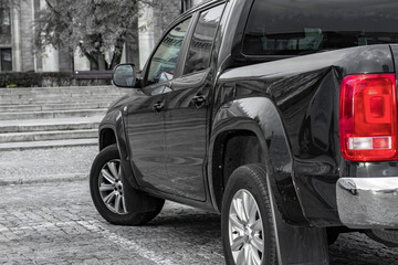 large SUV rear view. against a backdrop of granite steps and wood