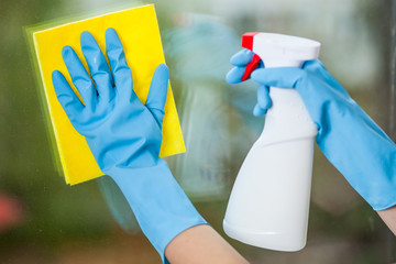 Hand in glove washes a window