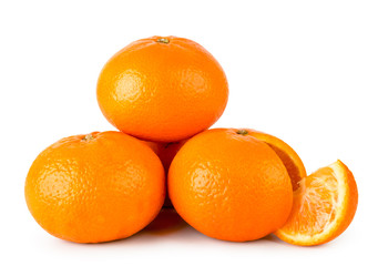 A bunch of ripe tangerines and a cut piece on a white. Isolated.