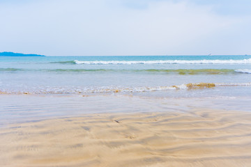 Fototapeta na wymiar sandy beach with blue waves Sea background
