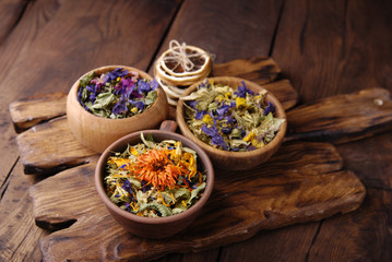 Dry herbs in military uniform on wooden background.