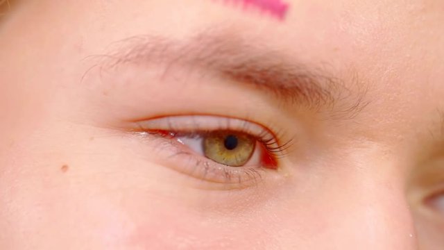Close-up shot of a cosmetoligist brushing eyebrows.