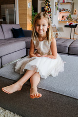 Little Girl in Holiday Dress Sitting on Sofa