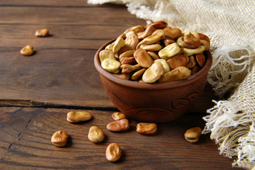 Dry the beans in the bowl and in the scoop on the wooden kitchen table.