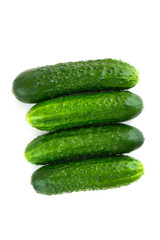 Fresh green cucumbers on a white background. Four cucumbers closeup isolated on white background.