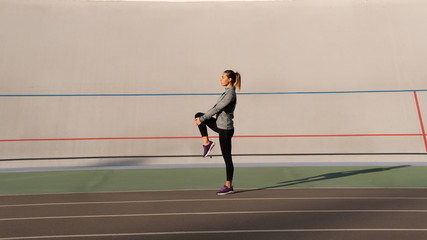 Fitness lady makes morning sport exercises on the running track
