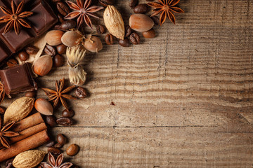 Texture spilling coffee beans, chocolate, cinnamon and cloves. Top view. Copy space.