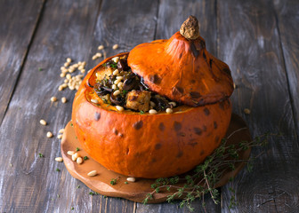 Pumpkin stuffed with crunchy croutons, mushrooms, leek and celery with thyme and pine nuts on a...