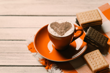 photo of the cup of coffee and cookies on the tablecloth on the white wooden background