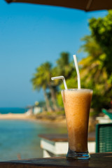 tropical fresh Fruit juice on the background of the sea vertical