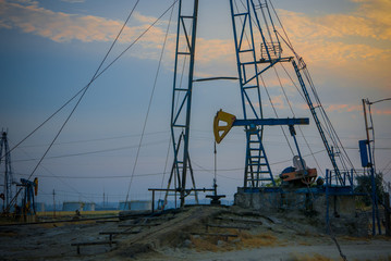 Petrol extraction, oilfield with petrol storage tanks in the background