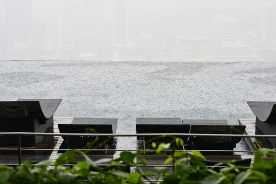 Rain fall in a infinity swimming pool, rainy day of holiday
