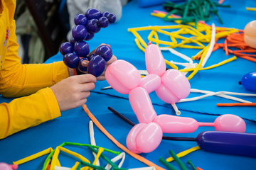 Happy children girl's hands with balloon on twisting art workshop - 229639009