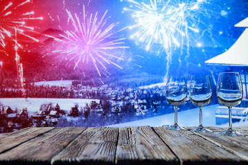 Glass wine glasses on a wooden board in a beautiful winter environment   