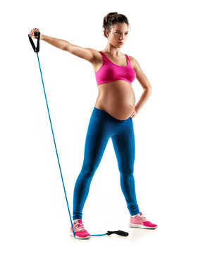 Sporty pregnant woman workout with expander isolated on white background. Concept of healthy life