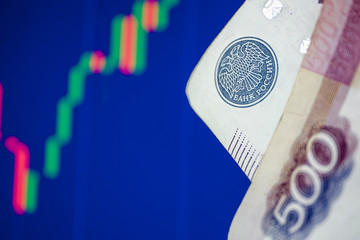 The concept of the fall and the growth of the ruble exchange rate. Five hundred rubles on the background of the blue chart.