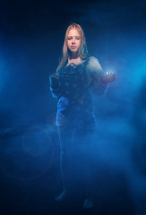 A girl stands in the smoke with the light in hand