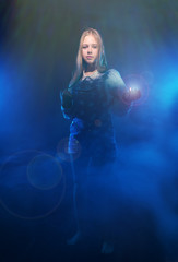 A girl stands in the smoke with the light in hand