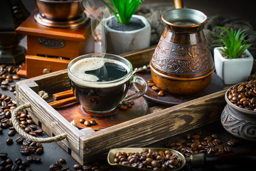 Black coffee in a cup on old background