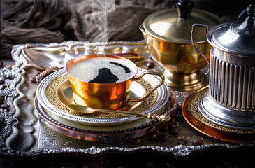 Black coffee in a cup on old background