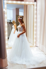 Beautiful bride is trying on an elegant wedding dress