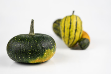Decorative pumpkin on a white kitchen table. Fruit for halloween for decorations.
