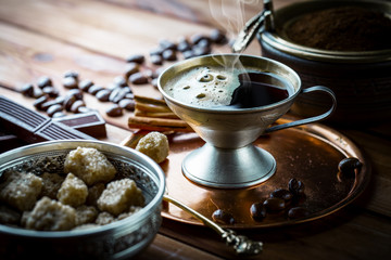 Black coffee in a cup on old background