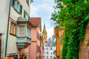 Obraz premium Beautiful cozy street and tower of Saint Peter church in the city center of Zurich, Switzerland