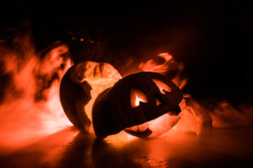 Horror Halloween concept. Close up view of scary dead Halloween pumpkin glowing at dark background.