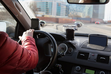 driver's hand on the steering wheel of a driving car