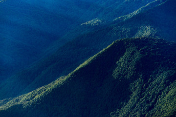 Landscape with mountains covered by forest and sunshine.