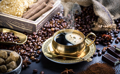 Black coffee in a cup on old background