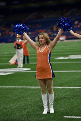 Young college cheerleader performing at a college football game