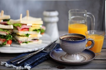 Fresh tasty sandwich with lettuce, ham, cheese, avocado, and tomato. English breakfast