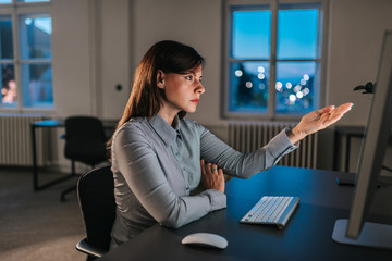 Displeased businesswoman pointing at computer screen. Side view.