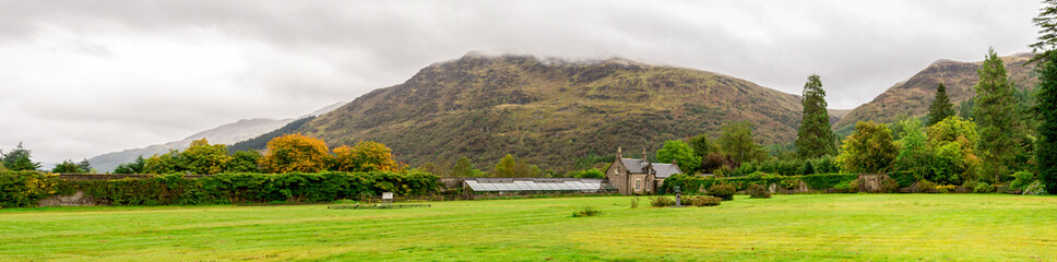 Fototapeta na wymiar Panorama of the lawn in front of a glasshouse with plants in Benmore Botanic Garden, Scotland