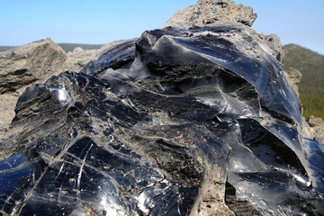 Large chunks of black obsidian glass exposed