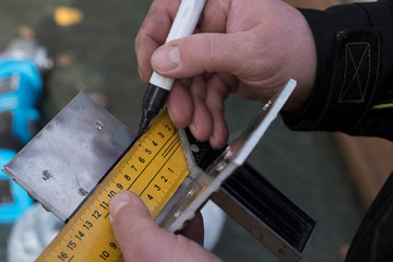 A man's hand writes with a black marker on metal. The wizard markup