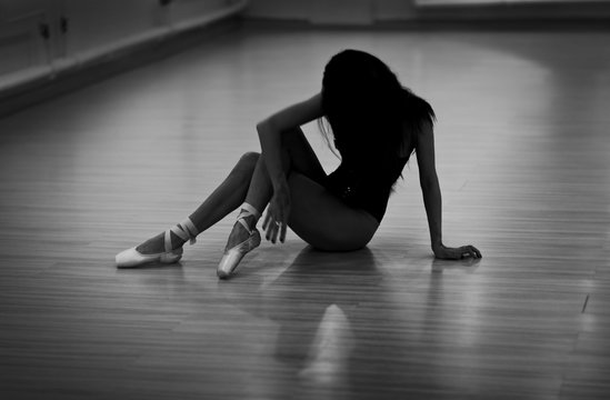 A photo of ballerina in pointes in dance studio. Black and white