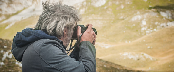 Professional photographer take picture of landscape at the mountain peaks