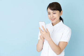 portrait of young asian nurse on blue background