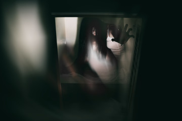 blurry image and double exposure ghost woman hand in haunted hotel with dark filter, halloween...