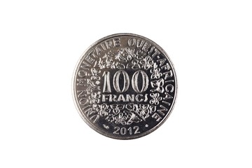 A close up image of a silver 100 West African franc coin isolated on a white background